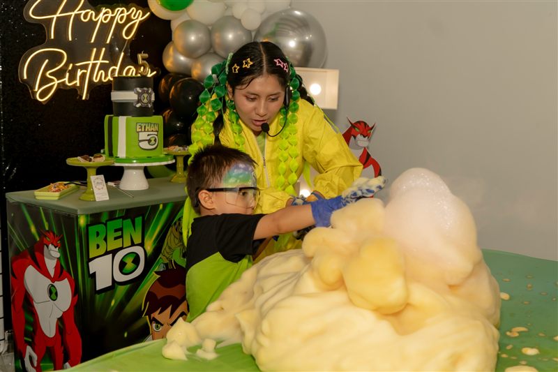 Niño tocando una gran espuma de colores en el show de ciencia de su fiesta