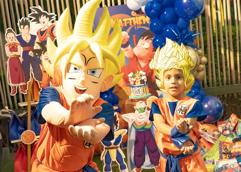 Niño con peluca de Goku junto al muñeco de Goku en su fiesta de Dragon Ball