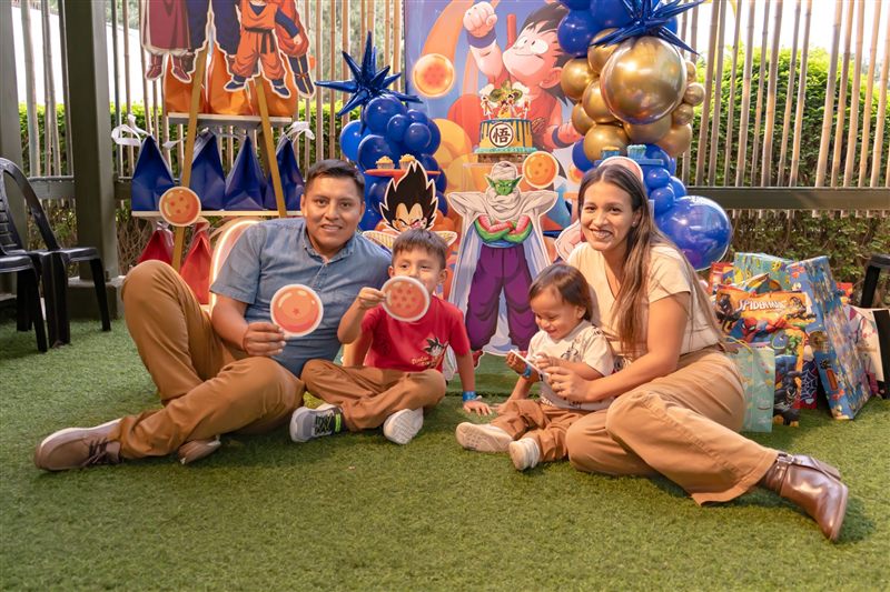 Familia sentada en el pasto con esferas del dragón en una fiesta de Dragon Ball