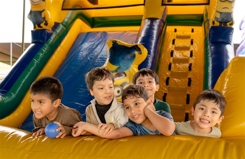 Cinco niños asomados en un castillo inflable de Minions