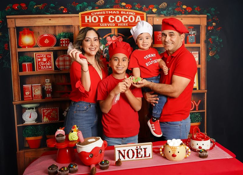 Familia con camisetas rojas, un niño con gorro de cocinero blanco y galletas decoradas